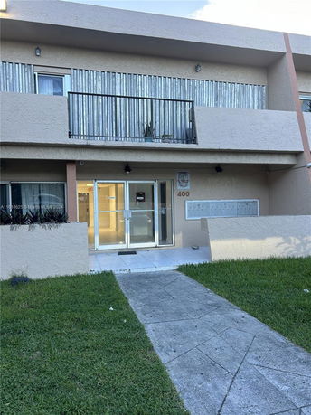 Front view of a two-story building with a balcony and entrance.