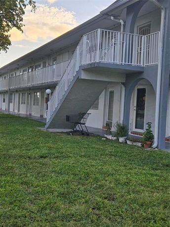 Front view of a two-story apartment building with exterior stairs and balconies.