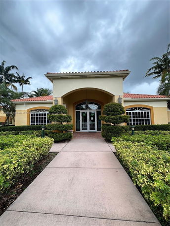 Front view of a single-story building with an arched entrance and large windows.