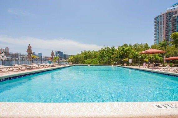 Outdoor swimming pool with deck chairs and umbrellas.