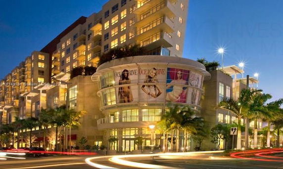 Front view of a multi-story building with commercial and residential sections.