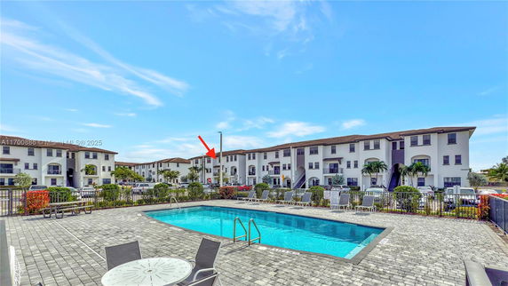 Outdoor swimming pool area with surrounding apartment buildings.