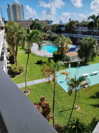 View overlooking a swimming pool and garden area in a residential complex.