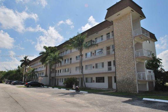 Front view of a multi-story residential building with balconies and stone accents.