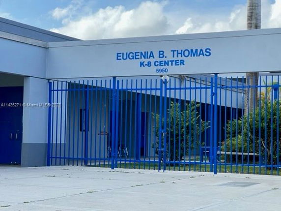 Front view of a building with blue gates and signage.