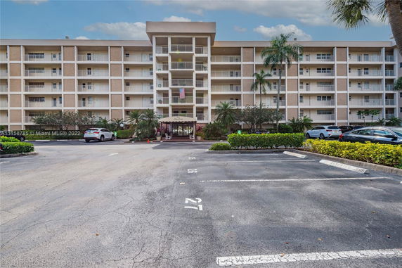 Front view of a multi-story residential building with balconies and a central entrance.