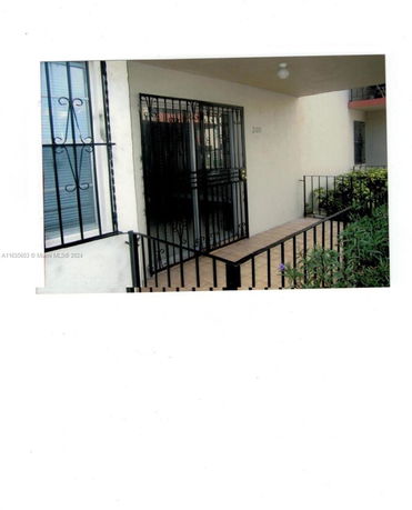 Front view of a building entrance with a gated door and railing.