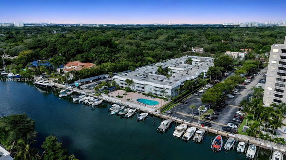 Panoramic view showing a waterfront building with a swimming pool and boats docked nearby.