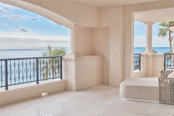 Outdoor terrace with ornate railing overlooking the ocean.