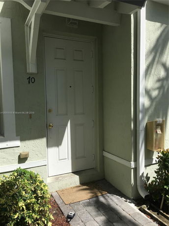 Front door of a house with light green exterior and white trim.