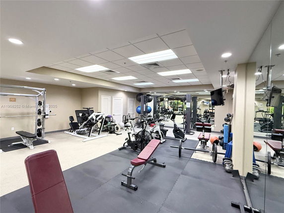 Interior view of a gym area with various exercise equipment including weights, benches, and cardio machines.