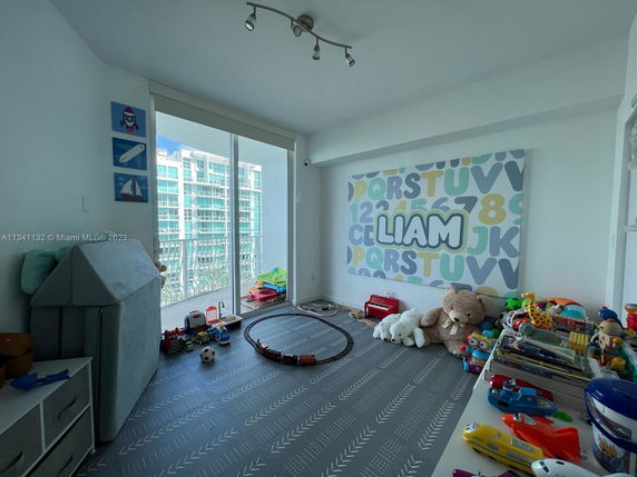 Children's playroom with toys and a balcony view.