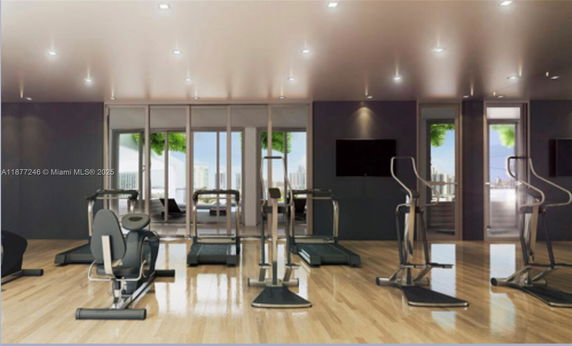Interior view of a modern gym area with exercise equipment and large glass doors.