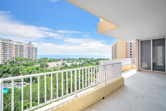 Balcony view overlooking coastal landscape and buildings.