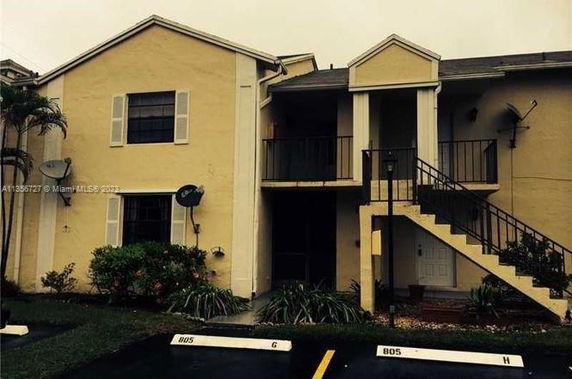 Front view of a two-story residential building with stairs.