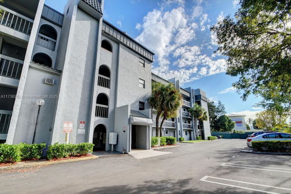 Front view of a multi-story building with balconies and arched openings.