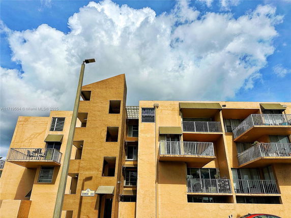 Front view of a multi-story apartment building with balconies.