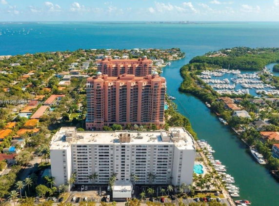 Aerial view of waterfront residential buildings with marinas and ocean in the background.