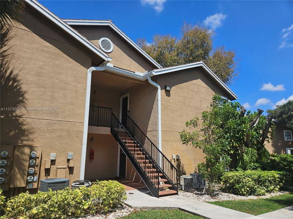Front view of a building with an external staircase leading to the entrance.