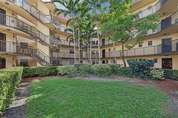 Exterior view of a multi-story apartment building with open walkways and staircases.