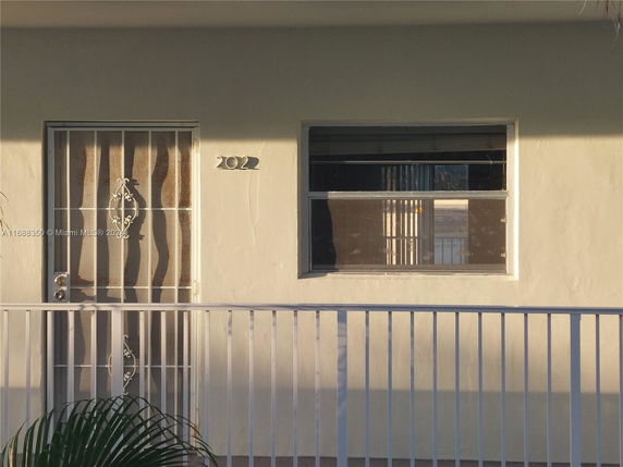 Front view of a building with a metal door and railing.