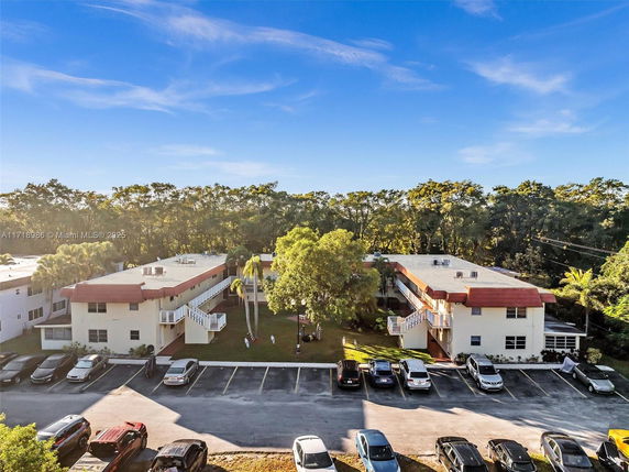 Elevated view of two-story buildings with parking area in front.
