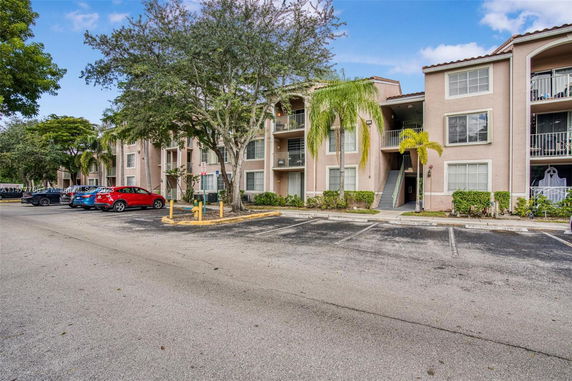 Outdoor parking area in front of a multi-story residential building.