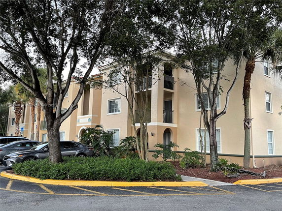 Front view of a multi-story residential building with balconies and windows.