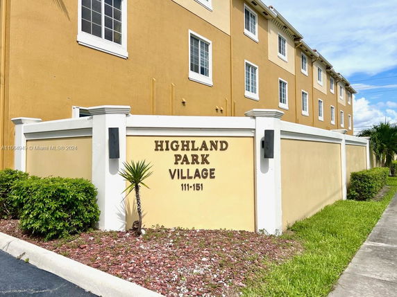Front view of a multi-story building with a beige exterior and multiple windows.
