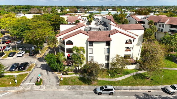 Front view of a multi-story apartment building with a tiled roof.