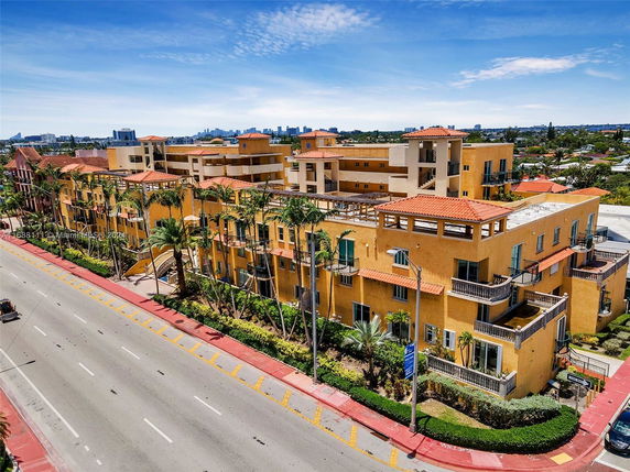 Front view of a multi-story apartment building with balconies and a flat roof.