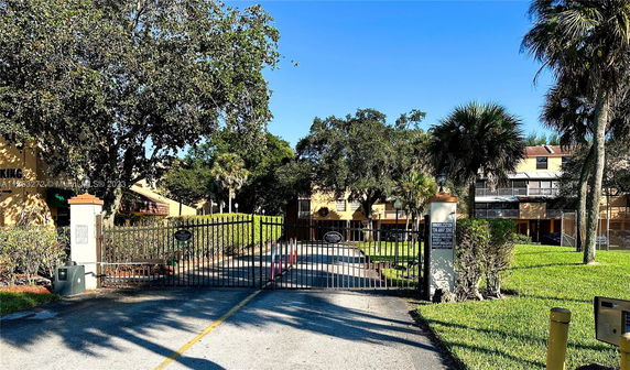 Front view of a gated residential complex with multiple buildings.