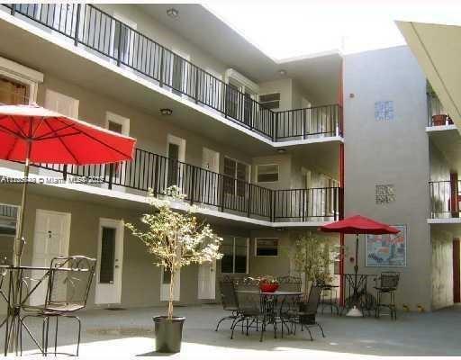 View of an apartment building courtyard with outdoor seating and multiple stories.