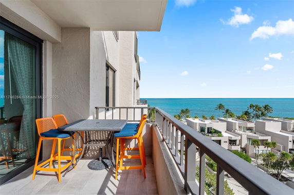 Balcony view overlooking the ocean with nearby residential buildings.