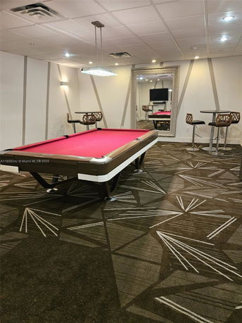 Indoor recreation area with a pool table and seating.