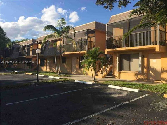 Front view of a two-story apartment building with balconies and stairs.