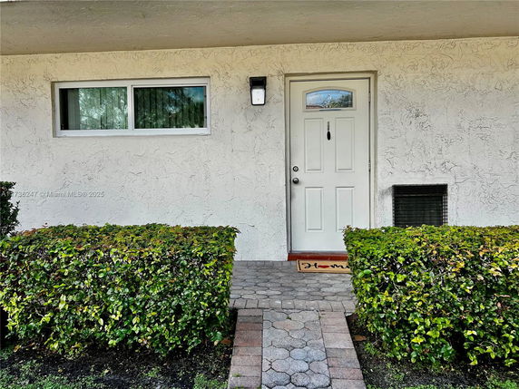 Front view of a building entry with a white door and a window.