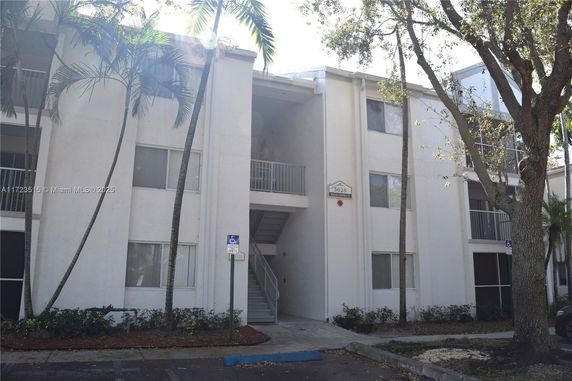 Front view of a three-story residential building with outdoor stair access.