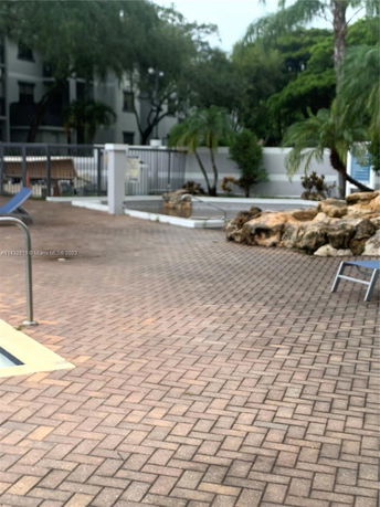 Outdoor area with paved flooring and swimming pool.