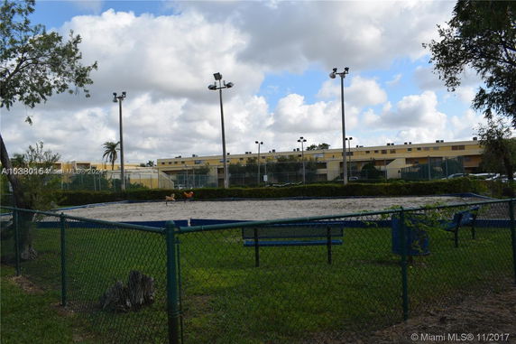 Outdoor recreational area with a sandy ground and surrounding fence.