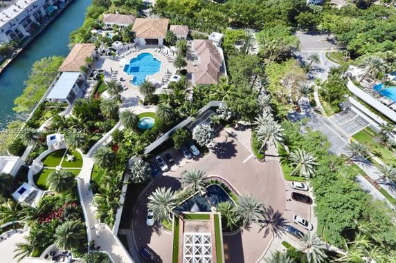 Aerial view of a residential complex with a swimming pool and greenery.