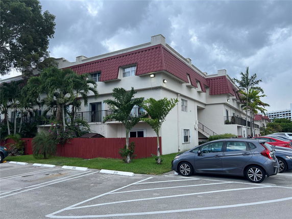 Front view of a multi-story building with red tiled roofs and various balconies.