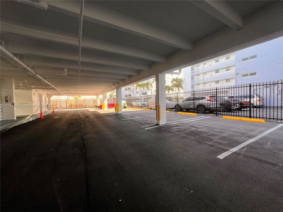 Covered outdoor parking area with several parked cars.