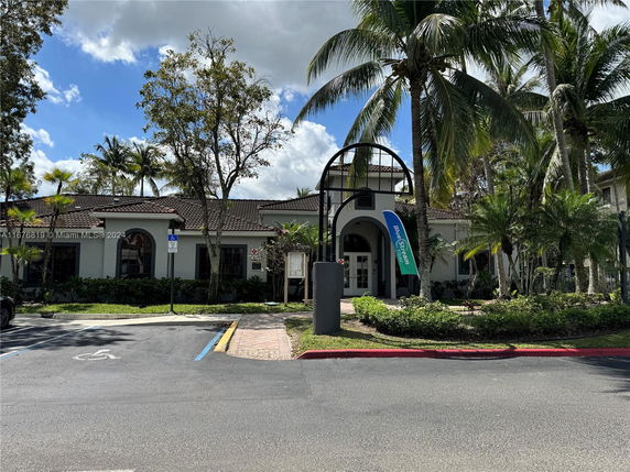 Front view of a building with a tiled roof and arched entrance.