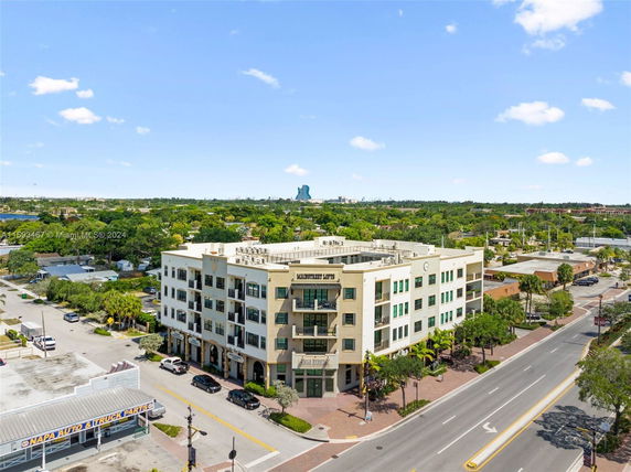 Front view of a multi-story commercial building with balconies and large windows.