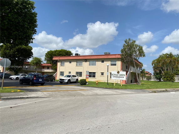 Front view of a two-story condominium building with a sign reading Royale Green Condominium.