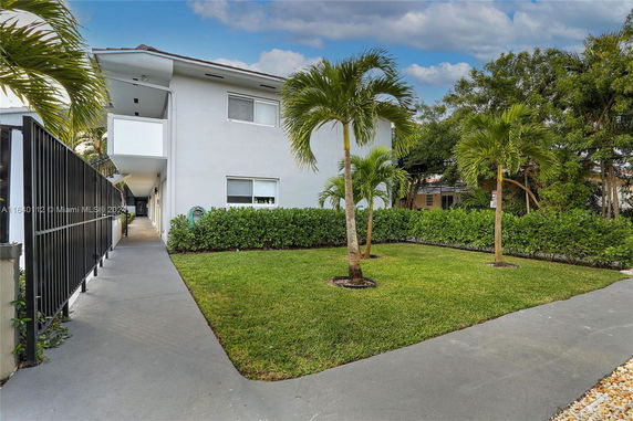 Front view of a two-story building with a pathway and lawn.
