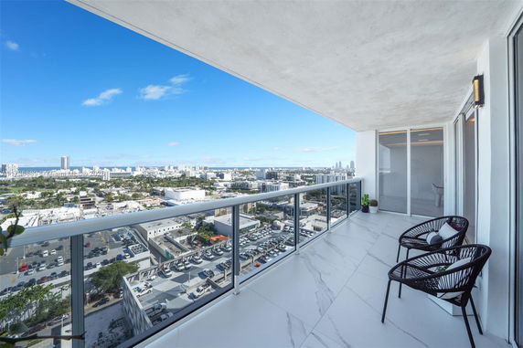 View from a high-rise balcony overlooking a cityscape.