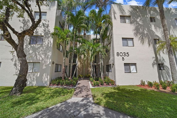 Front view of a multi-story apartment building with a beige exterior and marked as 8035 B.