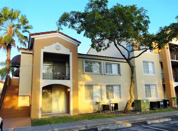 Front view of a two-story building with balconies and window units.